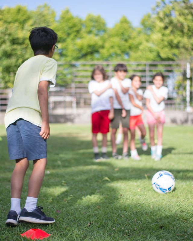 A child controlling a soccer ball on the grass
