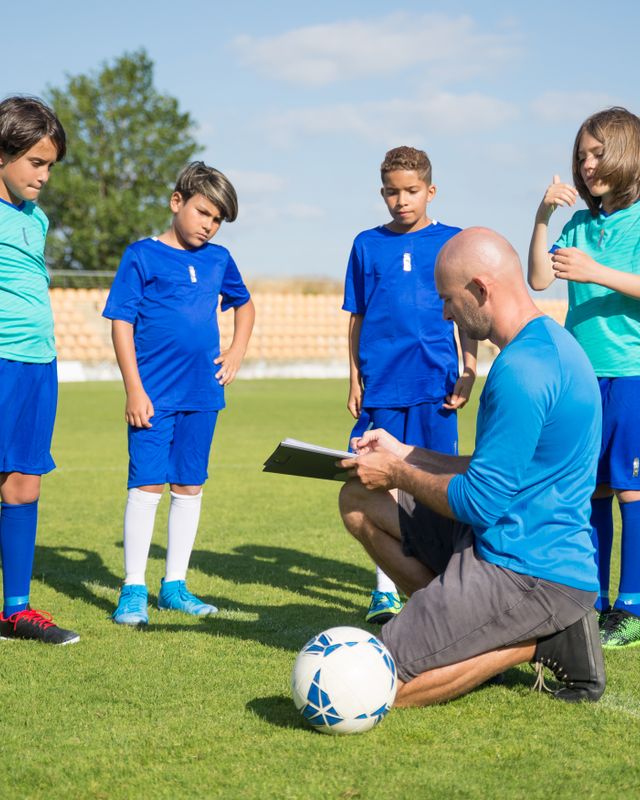A coach giving instructions to young players