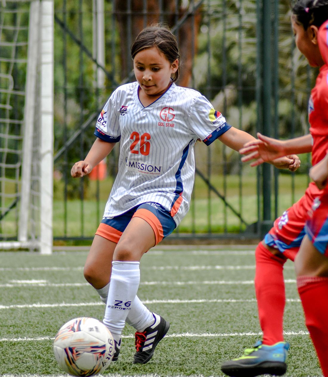 A young soccer player dribbling the ball during a game