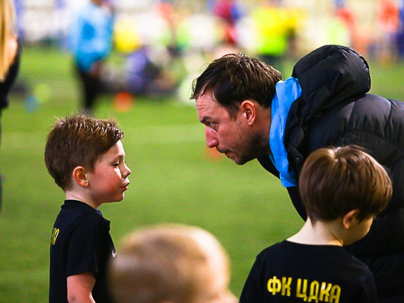 A coach mentoring a young player one-on-one